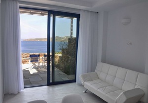 Windmill and houses by the sea / Stavros Bay