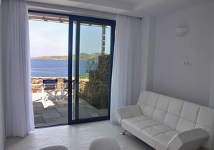 Windmill and houses by the sea / Stavros Bay