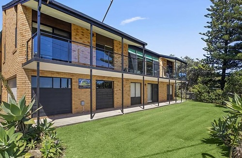 Sawtell House | Step out onto the sunny balcony of Peninsula - a spacious beachside home with superb ocean views.